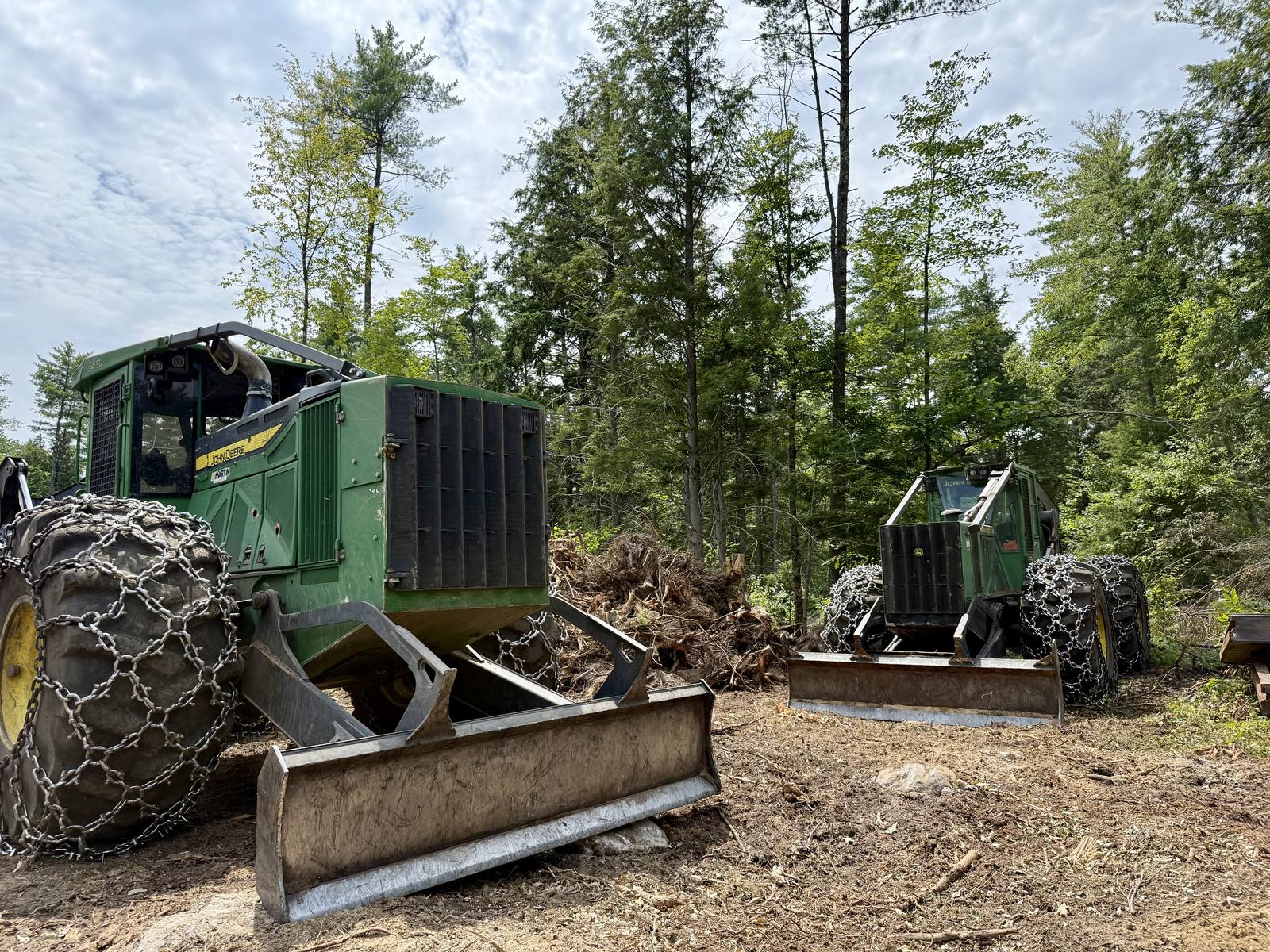 John Deere logging equipment clearing a forested site in Maine